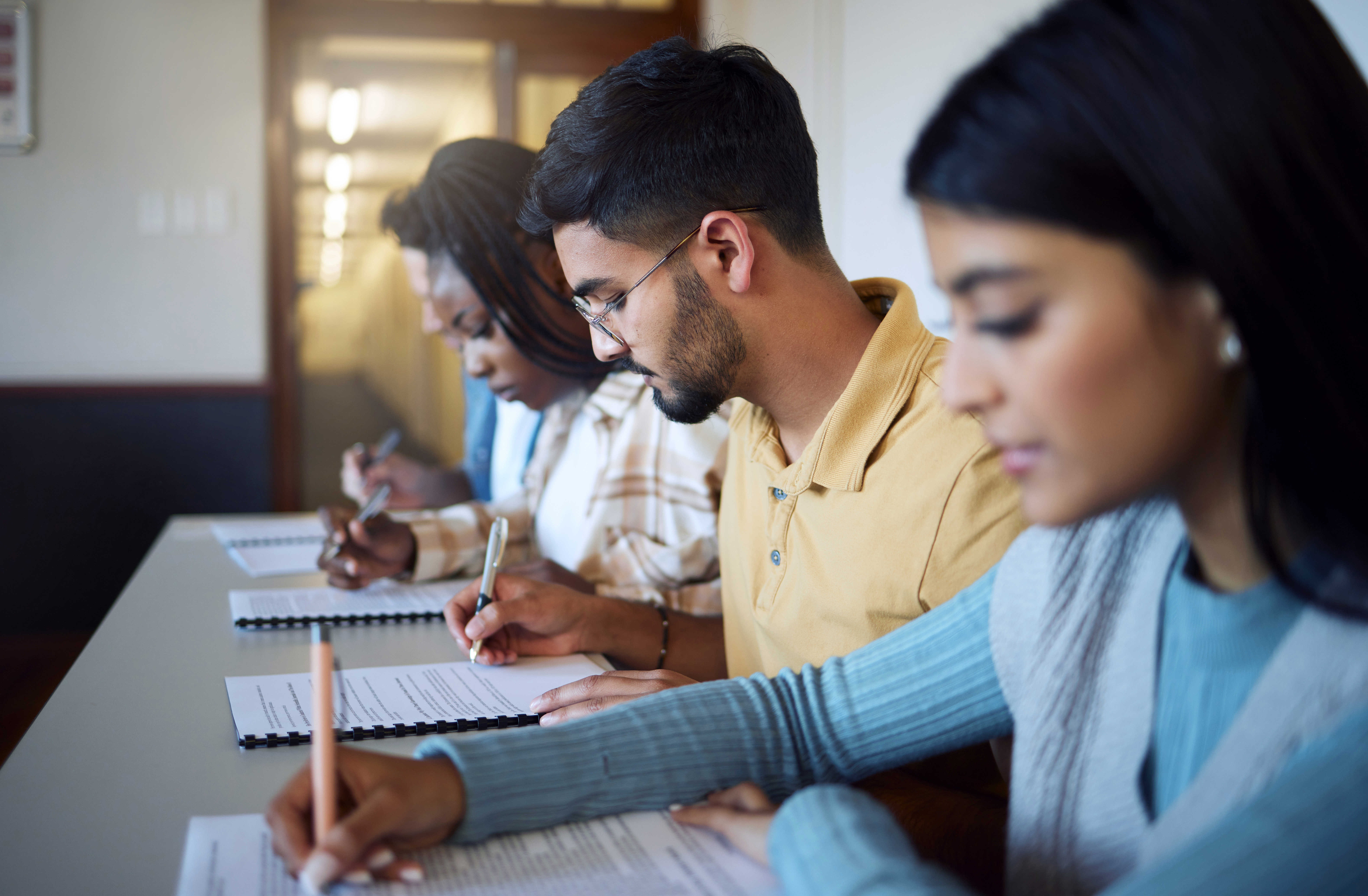 Unge mennesker skriver på papirblokke