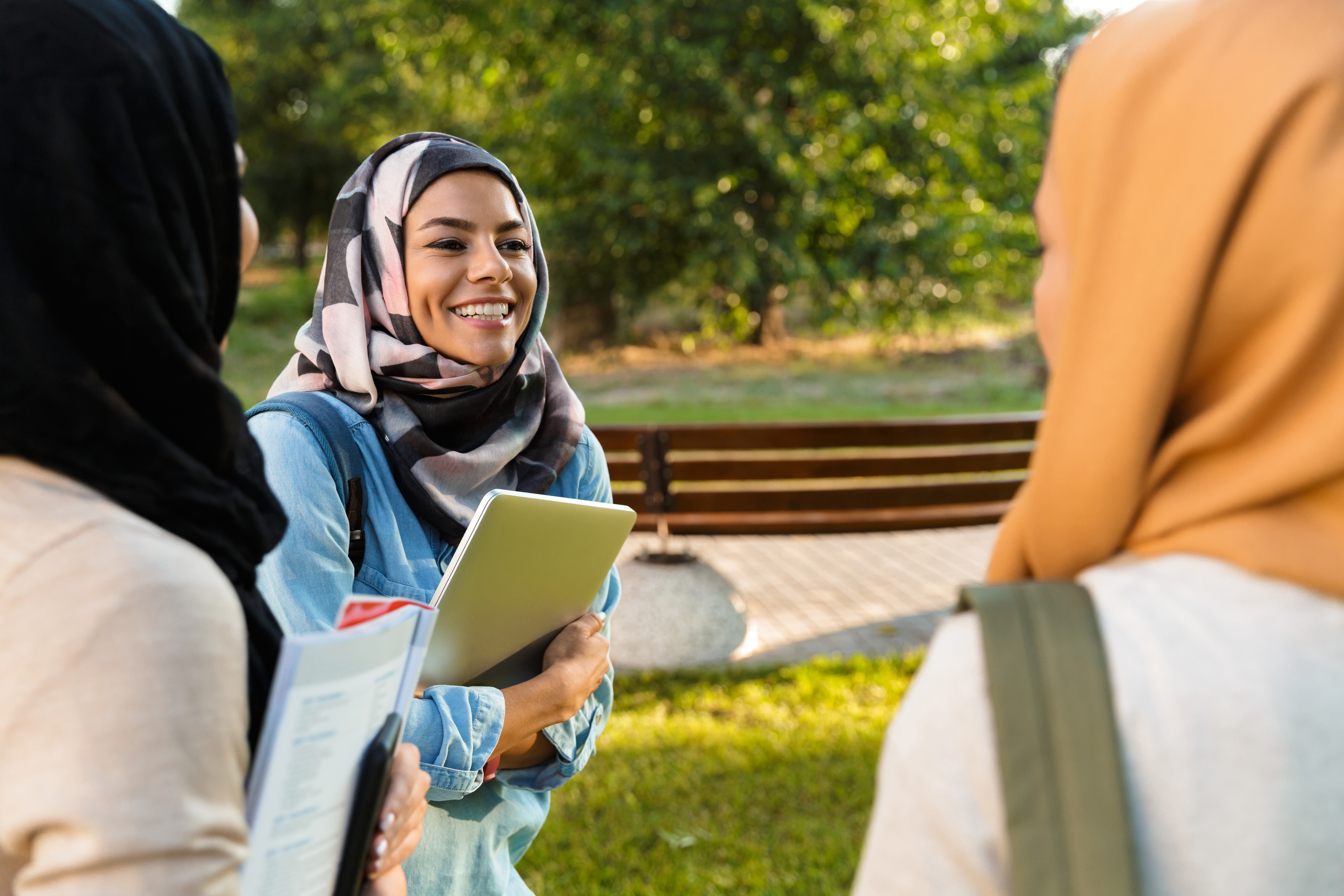 Tre smilende kvinder iført hijab
