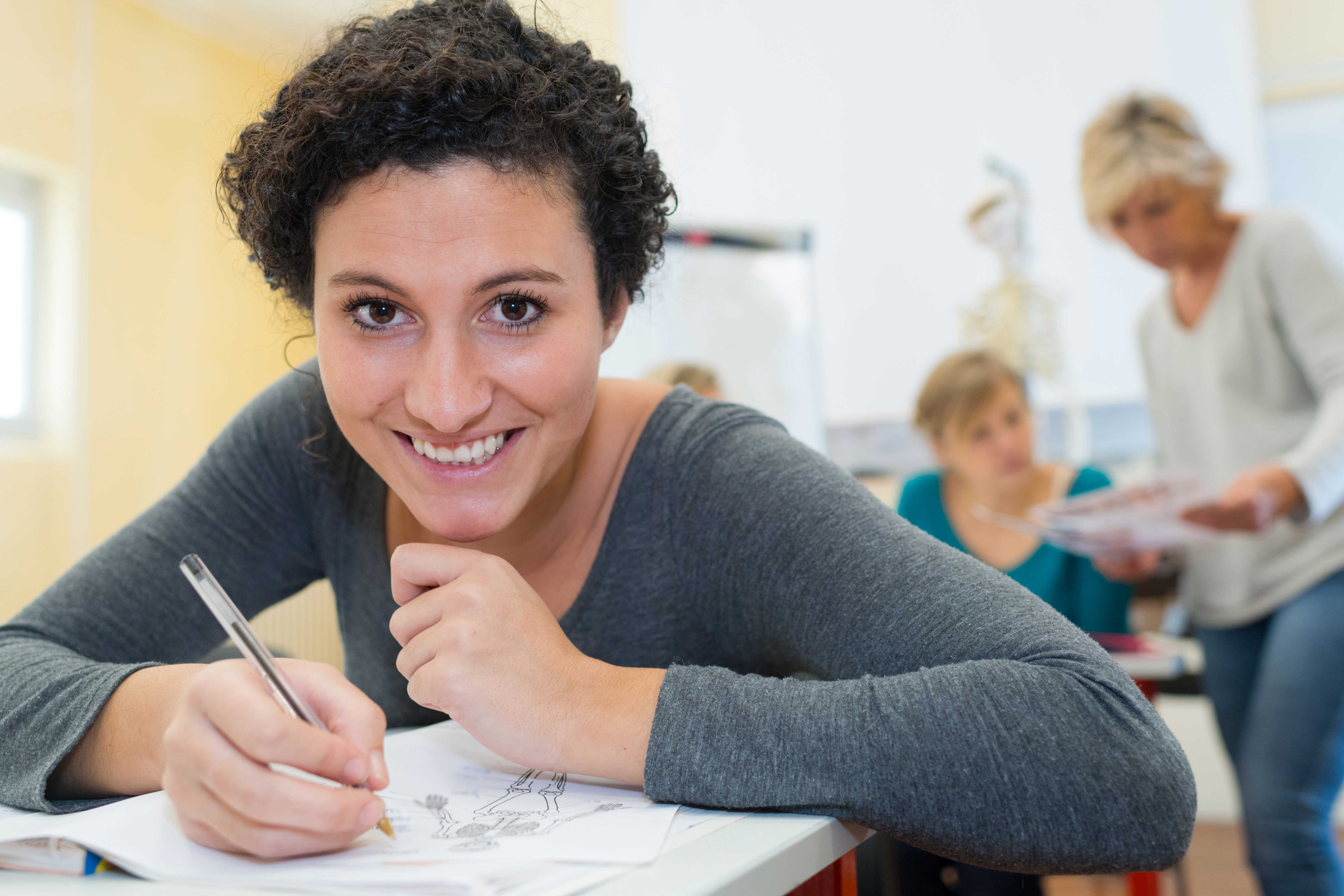 Mørkhåret kvinde tegner på et papir