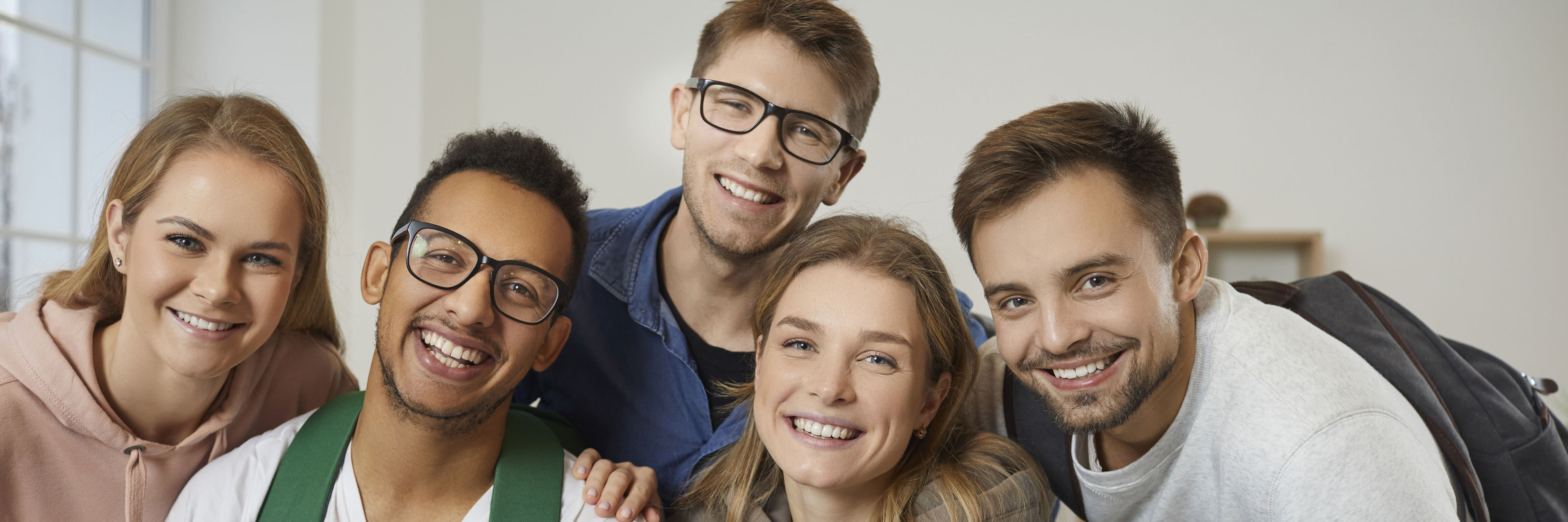 Unge mennesker står sammen og smiler